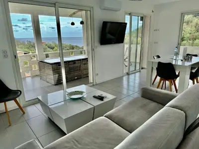 a living room with a couch and a table at Villa Mare è Machja avec piscine et vue mer in Sari Solenzara