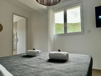 a bedroom with a bed with two pillows on it at Appartement Mare è Machja avec piscine et vue mer in Sari Solenzara