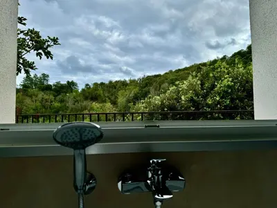 a bathroom window with a view of a mountain at Appartement Mare è Machja avec piscine et vue mer in Sari Solenzara