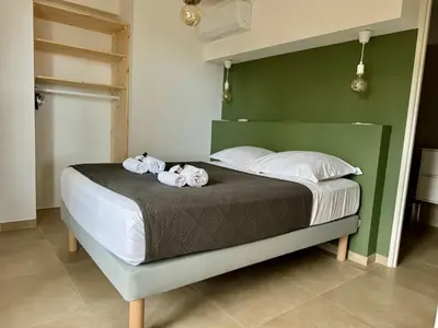 a bedroom with a bed with two towels on it at Appartement Mare è Machja avec piscine et vue mer in Sari Solenzara