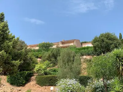 a garden with bushes and trees and a building at Maison Corallo splendide vue mer in Porto-Vecchio