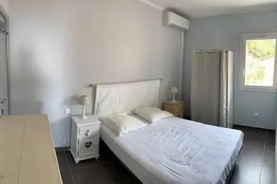 a bedroom with a white bed and a window at Maison Corallo splendide vue mer in Porto-Vecchio