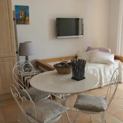a table and chairs in a room with a bed at Residence CORSE AZUR AJACCIO in Ajaccio