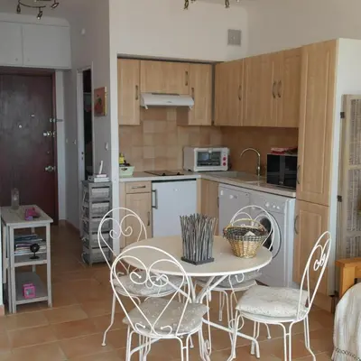 a kitchen with a table and chairs in a room at Residence CORSE AZUR AJACCIO in Ajaccio