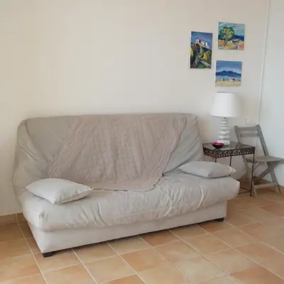 a couch sitting in a living room with a table at Residence CORSE AZUR AJACCIO in Ajaccio