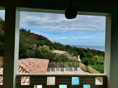 a view of the ocean from a house window at Appartement Mare è Machja vue mer in Sari Solenzara