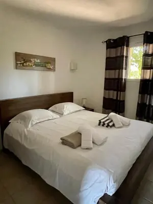 a bedroom with a large white bed with towels on it at Résidence Santa Giulia Park 1 avec piscine à proximité des plages in Porto-Vecchio