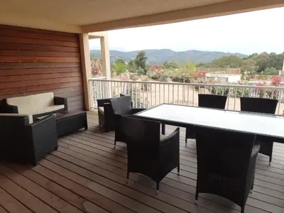 a patio with a table and chairs on a deck at Résidence Santa Giulia Park 1 avec piscine à proximité des plages in Porto-Vecchio