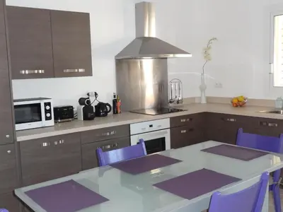 a kitchen with a table and purple chairs in a kitchen at Résidence Santa Giulia Park 1 avec piscine à proximité des plages in Porto-Vecchio