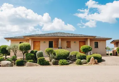 a house with bushes and trees in front of it at Résidence Les Terrasses de Rondinara in Bonifacio