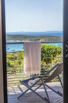 a towel is hanging on a chair on a balcony at Résidence Les Terrasses de Rondinara in Bonifacio