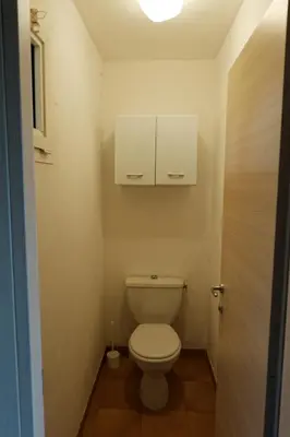 a bathroom with a toilet with a cabinet above it at COCON AUX SENTEURS de CORSE et VUE EXCEPTIONNELLE in Linguizzetta
