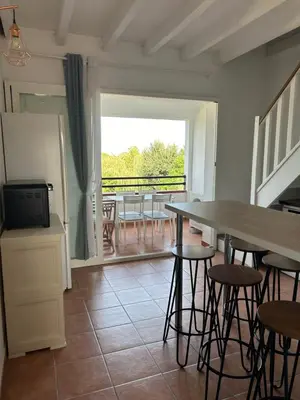a kitchen with a table and chairs and a balcony at Appartement dans résidence avec piscine et plage privées in San-Nicolao