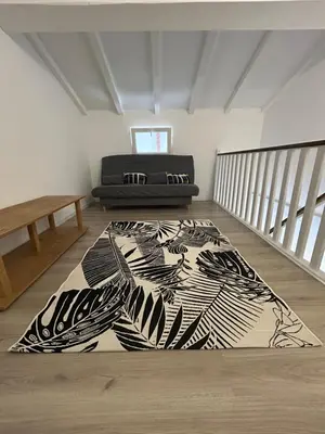 a room with a black and white rug on the floor at Appartement dans résidence avec piscine et plage privées in San-Nicolao