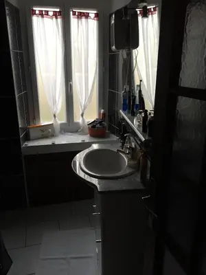 a bathroom with a sink and two windows at Studio Haute Ville in Corte