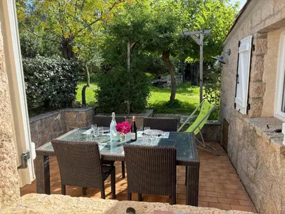 a patio with a table and chairs on a patio at Caseddu jardin et mer in Viggianello