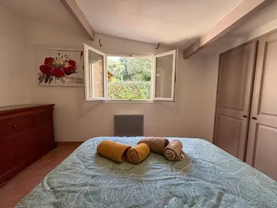 a bedroom with a bed with a window at Caseddu jardin et mer in Viggianello