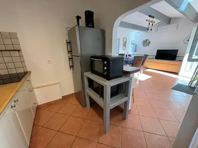a kitchen with a refrigerator and a tv on a table at Caseddu jardin et mer in Viggianello