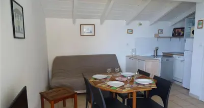 a kitchen and a table in a room with a couch at Résidence Fioravanti Villas Valinco in Tizzano