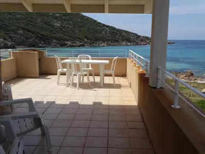 a balcony with a table and chairs and the ocean at Résidence Fioravanti Villas Valinco in Tizzano