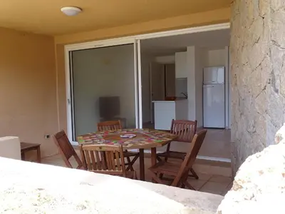 a kitchen and dining room with a table and chairs at Résidence Fioravanti Villas Valinco in Tizzano