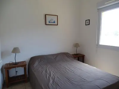 a bedroom with a bed and two tables and a window at Résidence Fioravanti Villas Valinco in Tizzano