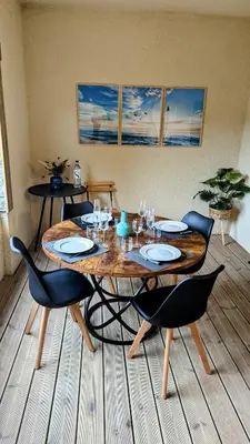 a wooden table with chairs and a wooden floor at Appart 70m2 avec loggia, piscine à débordement vue mer in Pianottoli-Caldarello