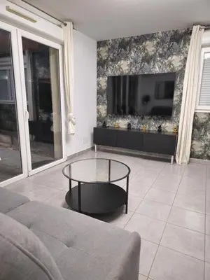 a living room with a table and a tv at Casa Ghjulia 4 étoiles à Porto-Vecchio centre-ville in Porto-Vecchio