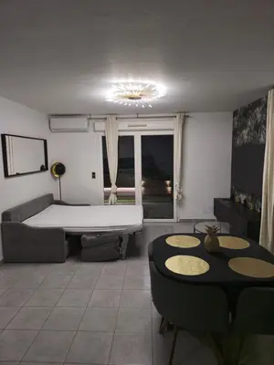 a living room with a bed and a table at Casa Ghjulia 4 étoiles à Porto-Vecchio centre-ville in Porto-Vecchio