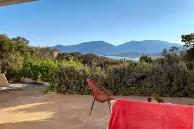 a red chair sitting on a patio with a table at Appartement T2 Belvedere campomoro in Portigliolo