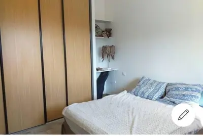 a bedroom with a bed and a wooden cabinet at Appartement T2 Belvedere campomoro in Portigliolo