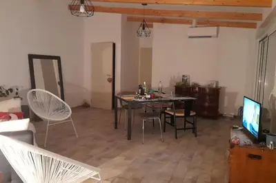 a living room with a table and chairs and a television at Appartement T2 Belvedere campomoro in Portigliolo