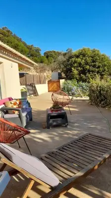 a patio with two chairs and a table at Appartement T2 Belvedere campomoro in Portigliolo