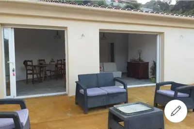 a living room with couches and a table and chairs at Appartement T2 Belvedere campomoro in Portigliolo