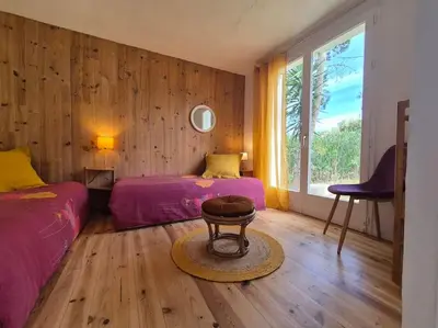 a bedroom with two beds and a table in it at La Bohème, route de Pinarello in Sainte-Lucie de Porto-Vecchio