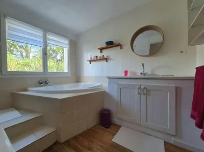 a bathroom with a tub and a sink and a mirror at La Bohème, route de Pinarello in Sainte-Lucie de Porto-Vecchio