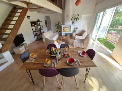 a living room with a wooden table and chairs at La Bohème, route de Pinarello in Sainte-Lucie de Porto-Vecchio