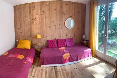 two beds in a room with wooden walls at La Bohème, route de Pinarello in Sainte-Lucie de Porto-Vecchio
