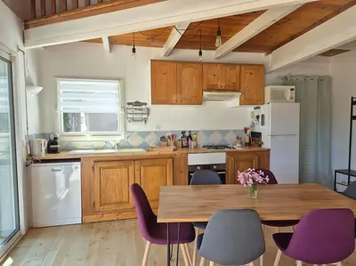 a kitchen with a wooden table and purple chairs at La Bohème, route de Pinarello in Sainte-Lucie de Porto-Vecchio