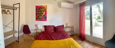 a bedroom with a bed with a yellow and purple blanket at La Bohème, route de Pinarello in Sainte-Lucie de Porto-Vecchio