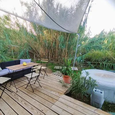 a wooden deck with a table and a tent at Résidence A Casetta in Monacia-dʼAullène