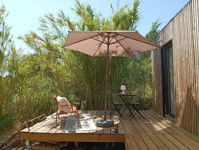 a wooden deck with a table and an umbrella at Résidence A Casetta in Monacia-dʼAullène