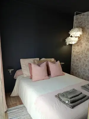 a bedroom with a white bed with pink pillows at Résidence A Casetta in Monacia-dʼAullène