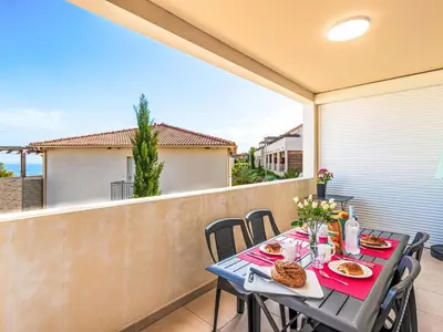 a table and chairs on a balcony with food on it at Apartment Mido by Interhome in Linguizzetta