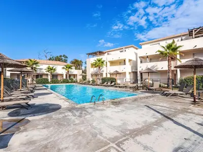 a pool with chairs and umbrellas at a resort at Apartment Mido by Interhome in Linguizzetta