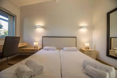 a bedroom with a large white bed with two pillows at Appartement 4* piscine et plage à pied in Porto-Vecchio