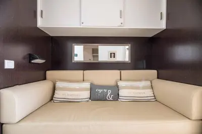 a couch with two pillows on it in a room at Appartement 4* piscine et plage à pied in Porto-Vecchio