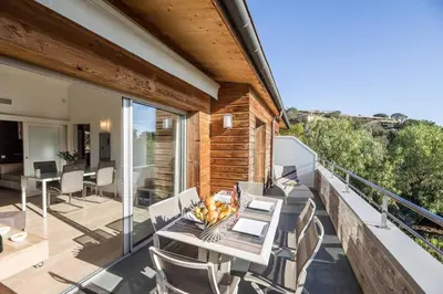 a patio with a table and chairs on a balcony at Appartement 4* piscine et plage à pied in Porto-Vecchio