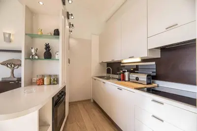 a kitchen with white cabinets and a counter top at Appartement 4* piscine et plage à pied in Porto-Vecchio