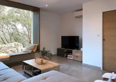 a living room with a couch and a tv at Villa d'architecte in Sotta